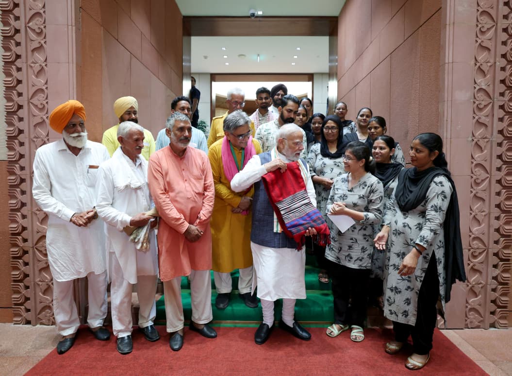 BJP4Haryana's tweet photo. #NationalHandloomDay के अवसर पर पंजाब की प्राकृतिक खेती पहल ‘खेती विरासत मिशन (KVM)’ के 20 सदस्यीय प्रतिनिधिमंडल ने आज संसद भवन में माननीय प्रधानमंत्री श्री @narendramodi जी से भेंट की।

प्रतिनिधिमंडल ने प्रधानमंत्री जी को प्राकृतिक खेती से उगाई गई स्वदेशी (नॉन-बीटी) कपास से तैयार, हाथ से काता और हाथ से बुना खादी का भारतीय तिरंगा भेंट किया। यह तिरंगा केवल एक उपहार नहीं, बल्कि भारत की मिट्टी, किसानों के परिश्रम और हमारे बुनकरों की विरासत का प्रतीक है।

प्रधानमंत्री मोदी जी ने वर्षों से खादी, हस्तशिल्प और स्थानीय उत्पादों को देश की पहचान बनाने का निरंतर प्रयास किया है। उनके प्रोत्साहन ने बुनकरों, कारीगरों और प्राकृतिक खेती से जुड़े किसानों के आत्मविश्वास को नई शक्ति दी है और “Vocal for Local” को जन-जन का अभियान बनाया है।