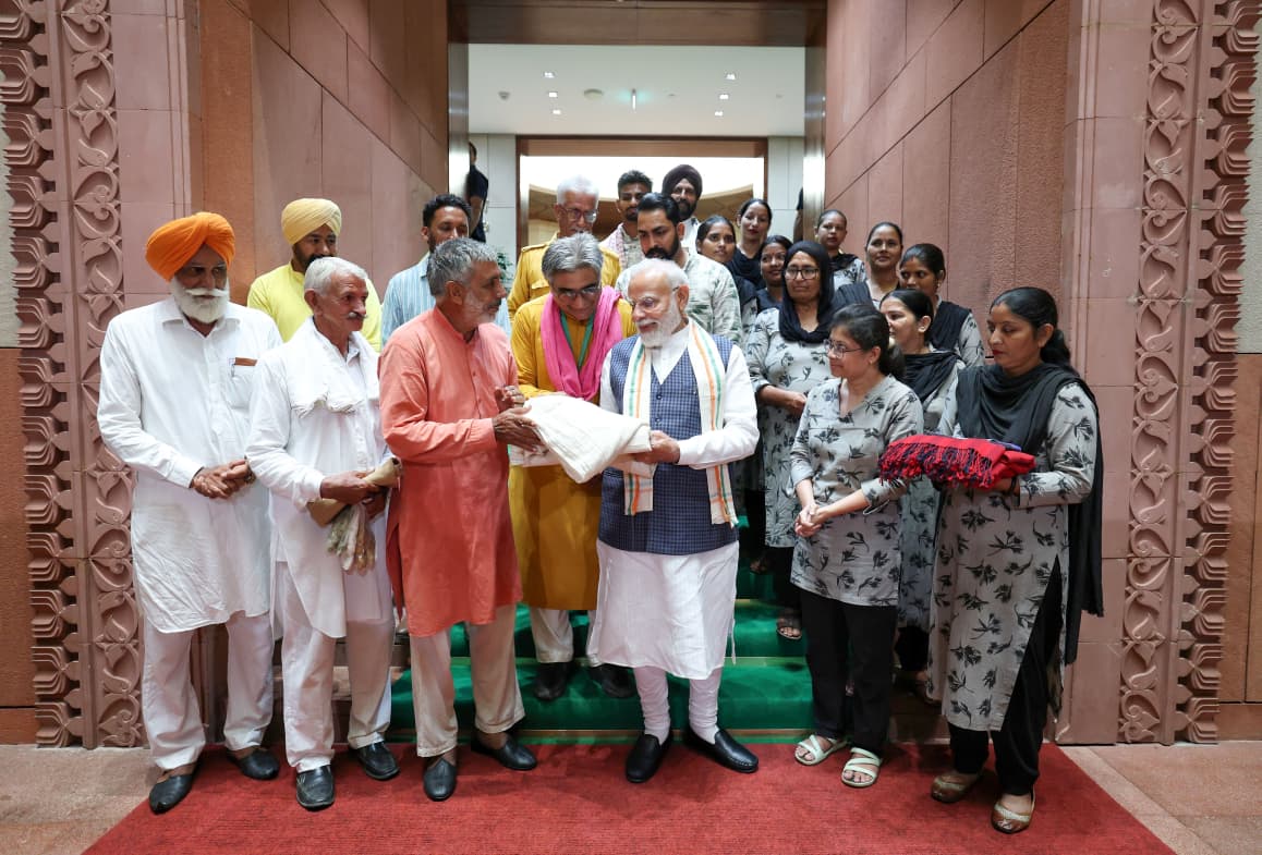BJP4Haryana's tweet photo. #NationalHandloomDay के अवसर पर पंजाब की प्राकृतिक खेती पहल ‘खेती विरासत मिशन (KVM)’ के 20 सदस्यीय प्रतिनिधिमंडल ने आज संसद भवन में माननीय प्रधानमंत्री श्री @narendramodi जी से भेंट की।

प्रतिनिधिमंडल ने प्रधानमंत्री जी को प्राकृतिक खेती से उगाई गई स्वदेशी (नॉन-बीटी) कपास से तैयार, हाथ से काता और हाथ से बुना खादी का भारतीय तिरंगा भेंट किया। यह तिरंगा केवल एक उपहार नहीं, बल्कि भारत की मिट्टी, किसानों के परिश्रम और हमारे बुनकरों की विरासत का प्रतीक है।

प्रधानमंत्री मोदी जी ने वर्षों से खादी, हस्तशिल्प और स्थानीय उत्पादों को देश की पहचान बनाने का निरंतर प्रयास किया है। उनके प्रोत्साहन ने बुनकरों, कारीगरों और प्राकृतिक खेती से जुड़े किसानों के आत्मविश्वास को नई शक्ति दी है और “Vocal for Local” को जन-जन का अभियान बनाया है।