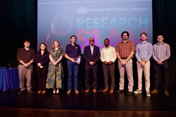 All participants of the research slam on the stage with lab director Johney Green