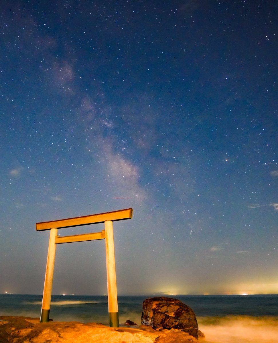 neko__tencho's tweet photo. #よつばみーつけたっ

今週はスター・ウィーク！！
〜ペルセウス座流星群がやってくる〜 🌌☄️

よつばとおでかけシリーズ🍀
花火に続いて、今度は―――

星空撮影へ！！

といっても今回は、仕事が終わってからの夜のおでかけ。

向かった先は、知多半島・美浜町にある

「つぶてヶ浦の鳥居」

愛知県は名古屋をはじめ街の明かりが多く、星空撮影にとって最大の敵ともいえる「光害」の影響を受けやすい場所。

ところが、ここつぶてヶ浦まで来ると、条件のいい夜には驚くほどたくさんの星を見ることができます。

そして鳥居の向こうにカメラを向けてみると……。

出ました、天の川！！🌌

海辺に立つ鳥居。その向こうから空へ伸びていく淡い天の川。肉眼ではぼんやりでも、カメラで長時間露光すると、星の集まりが少しずつ浮かび上がってきます。

写真に写っている天の川銀河は、遠くにある別の銀河を外から眺めているのではなく、

「自分たちが住んでいる銀河を、その内側から見ている景色」

なんです。

そう考えると、ちょっと壮大ですよね。

そして夏の星空といえば、忘れてはいけないのが―――

「夏の大三角」✨

こと座のベガ、わし座のアルタイル、
はくちょう座のデネブ。

写真でみると、上の星が織姫(ベガ)右下の星が彦星(アルタイル)左下の星がデネブ(はくちょう座)

どれも明るい星なので、条件がよければ名古屋市内からでも見つけることができます。

そして、ここからちょっとだけ
七夕のお話🎋

ベガは、ご存じ織姫星。
アルタイルは彦星。

七夕伝説では、離ればなれになった織姫と彦星の間を天の川が隔て、年に一度、七夕の夜に会うことを許されたとされています。

実際の星空を見てみると……

本当に二人の間に天の川がある！！😳

「物語のとおり、川が邪魔してるわーー！！」

昔の人がこの星空を眺めながら物語を作ったのだと思うと、何百年、何千年と受け継がれてきた七夕が急に身近に感じられます。

そしてスター・ウィークの後にやってくる、夏の夜空の一大イベント。

ペルセウス座流星群☄️🌌

2026年は新月の時期と重なり、月明かりの影響が非常に少ない好条件。極大は8月13日の日中ですが、日本で狙うなら12日夜から13日未明が大本命です。

流星群という名前ですが、ペルセウス座だけを見ていればいいわけではありません。

流星は空の広い範囲に飛び出してくるので、天の川と一緒に写り込む可能性もあります。

ということで―――

花火の次は星空。

鳥居の向こうに広がる天の川。
その中で輝くデネブ。
天の川を挟んだ織姫と彦星。
そして、もうすぐ夜空を駆け抜けるペルセウス座流星群。

仕事帰りにちょっと寄り道したつもりが、気がつけば見上げていたのは何千、何万光年というスケールの世界でした。

今回は台風の影響もあって海はかなりのしけ模様。🌊波しぶきと風に悩まされながら、カメラを守りつつのなかなか大変な撮影になりました。