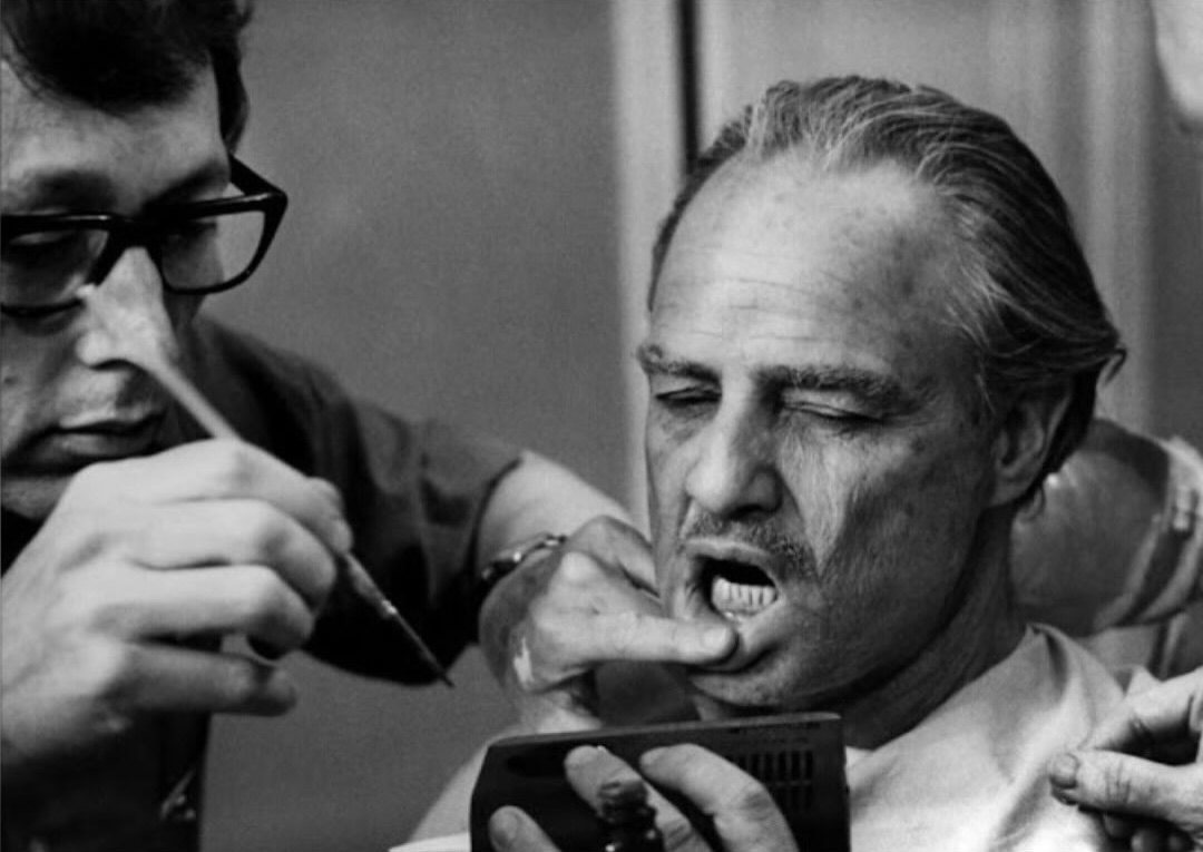 historyinmemes's tweet photo. Marlon Brando’s unusual dental prosthetic used for The Godfather.

When Marlon Brando prepared to play Don Vito Corleone in The Godfather (1972), he wanted the aging Mafia boss to have a heavy, sagging face reminiscent of a bulldog. During his screen test, Brando stuffed cotton into his cheeks to create the look. For filming, however, a custom dental prosthetic was made specifically for the role.

Known as a dental plumper, the device was designed by legendary makeup artist Dick Smith and fabricated by New York dentist Henry Dwork. Their first version was made from foam latex, but it made Brando’s face look too soft. It was replaced with a sturdier steel-and-resin mouthpiece that produced the distinctive jowls seen in the finished film.

The prosthetic did more than transform Brando’s appearance—it also affected the way he spoke, helping shape Don Corleone’s slow, mumbling voice. Although the device was uncomfortable and reportedly caused Brando to drool excessively during filming, it became an essential part of one of cinema’s most iconic performances.