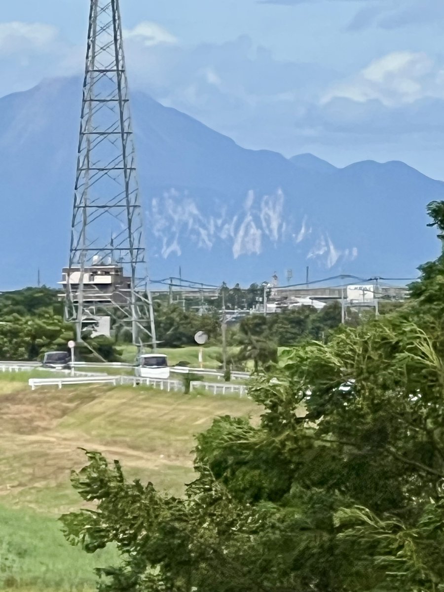 arrow_next's tweet photo. 今回の地震で島原の眉山斜面に崩落が発生したと報じられていたが、いつも見慣れてる眉山と比べると「何なんだコレ！」ってくらい複数箇所で崩落…。眉山全体的にダメージ受けてた‼️
鉄塔の奥高い山が普賢岳。
嘉島町釈迦堂橋から撮影 https://t.co/CGuIy0F1dQ