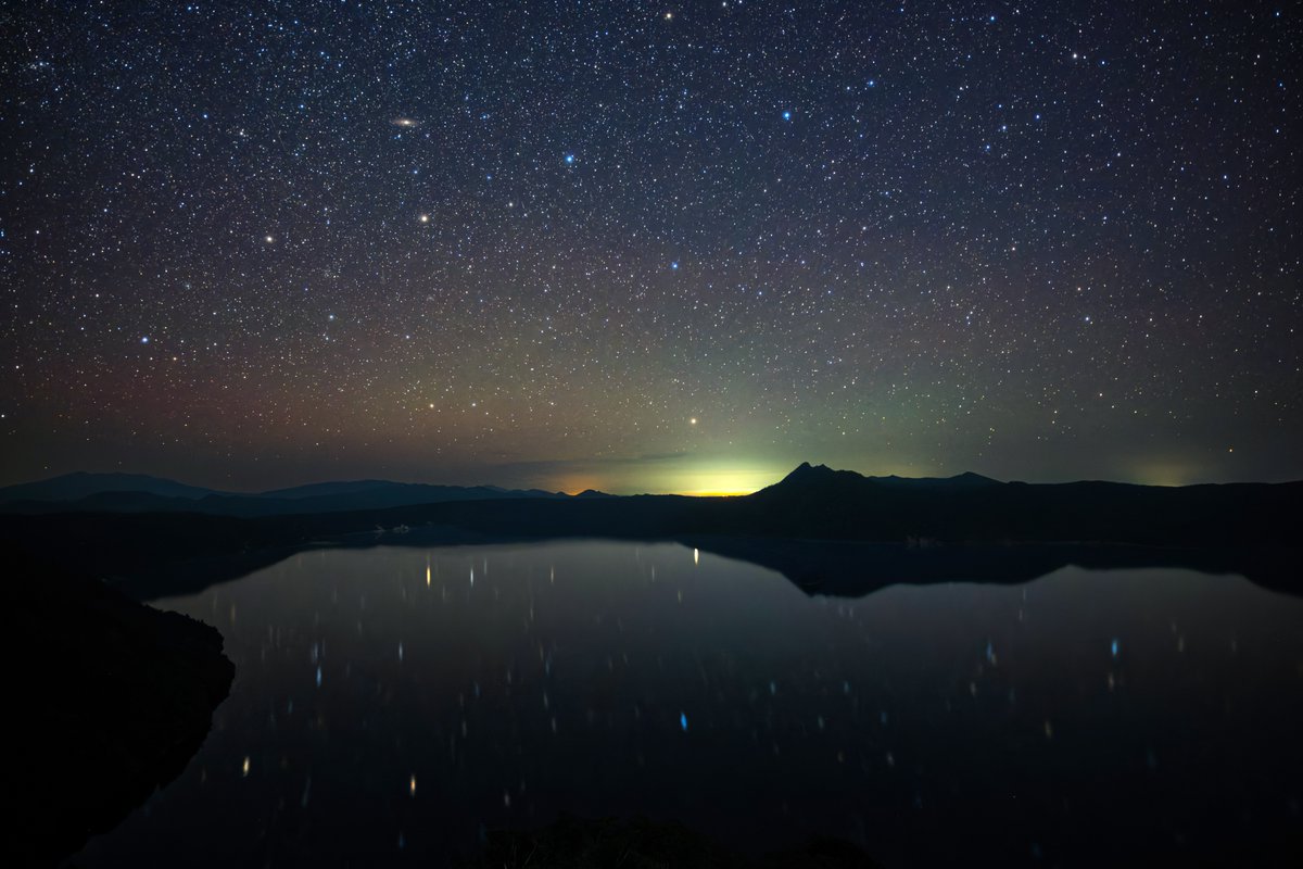 mashukoice's tweet photo. 昨夜訪れた摩周湖第３展望台からの星空です🌌
波がなく湖面が鏡になっていたので星が湖面に映る映る🌌
肉眼でも湖面に映っているのが見えます。
そしてアンドロメダ銀河も真ん中からやや左上方向に見えていますね。

夏は雲が湧くことが多いですが、昨日はバッチリでした👌 https://t.co/rOzeYs6PIz