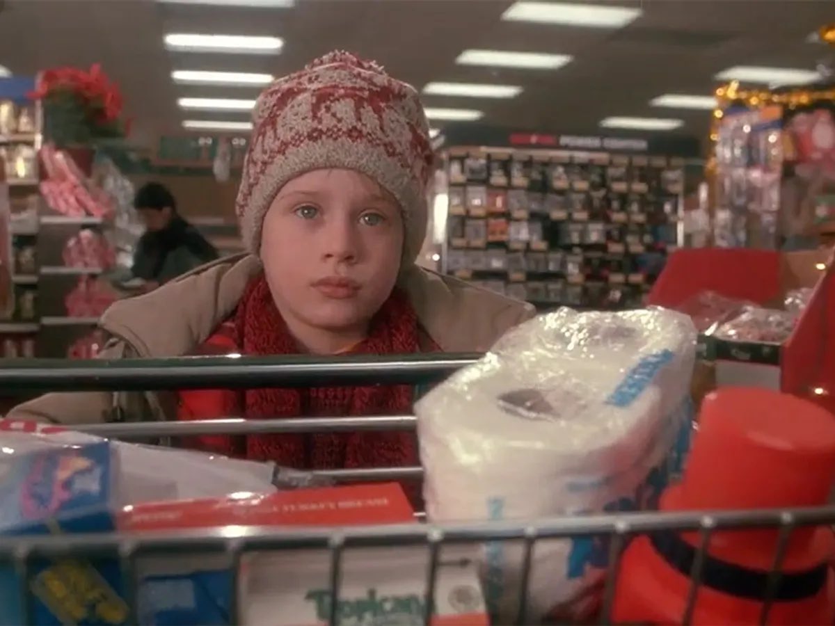 ThrillaRilla369's tweet photo. One of the most surprising facts about Home Alone is that Kevin actually paid the real 1990 prices during his famous grocery run. That full cart of milk, detergent, bread, toilet paper, fabric softener, mac & cheese, and snacks cost him exactly $19.83 — the authentic total for an American supermarket trip at the time. Today, Americans online are shocked by how drastically prices have changed. Since 1990, grocery costs have surged by over 280%. The same list of items that cost $19.83 back then was estimated at around $44.40 in 2023, roughly $74.52 in 2025, and by 2026 it hits approximately $78–$82 depending on state and store data. Kevin didn’t just defend his home — he accidentally delivered the most painful lesson in inflation, cost-of-living, and how much everyday life has changed.