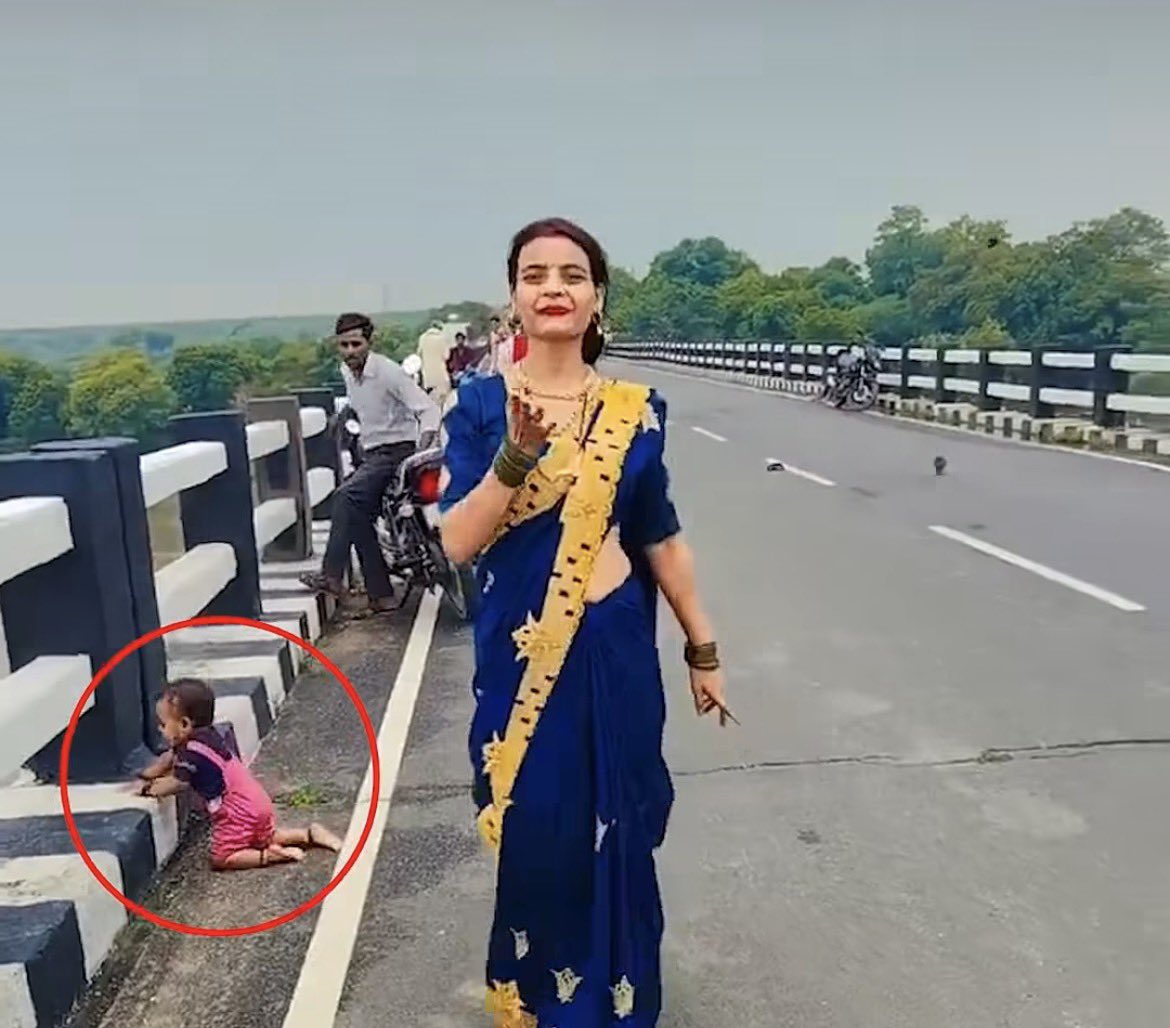 DNPofINDIA's tweet photo. रील एक भयानक बीमारी है!

शॉट लेने में महिला इतनी मदहोश है कि उसे अपना बच्चा नहीं दिख रहा है।

वह कैमरे के सामने पोज़ दे रही है लेकिन उसका बच्चा पुल के किनारे तक पहुँच गया।

जबसे पता चला है social media पैसे देता है तबसे गाँव की महिलाएँ क्रिएटर बनने के चक्कर में सठिया गई हैं।

ये बीमारी गाँव गली में कसके फ़ैल चुकी है।