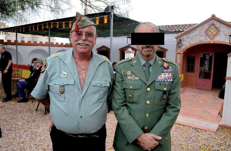 outsidersesp's tweet photo. Historia de un nazi alemán y su fortín de Alicante.

El exlegionario alemán Joachim Fiebelkorn, uno de los neonazis más temidos de la segunda mitad del siglo XX, investigado por una masacre en Italia y odiado en Bolivia por su papel como colaborador de la dictadura junto al capitán de la Gestapo Klaus Barbie, tiene un fortín en Alicante donde es arropado por guardias civiles, militares y camaradas legionarios.

En la localidad alicantina de Rojales hay una finca que emula a un castillo fortificado, con sus torretas, almenas, innumerables cámaras de seguridad y dos águilas imperiales custodiando un portón sobre el que se clava una gran bandera de España. En su interior hay un patio en el que un sacerdote celebra misa flanqueado por dos ametralladoras de gran calibre, un Cristo y una imponente Cruz de Hierro alemana. Se trata de un oficio veraniego por el apóstol Santiago, y son más de una docena los miembros de las fuerzas armadas cantando himnos patrióticos en un encuentro que exalta el lema de la Reconquista, “Santiago y cierra España”. La convocatoria ha sido lanzada por la Hermandad de Antiguos Caballeros Legionarios de la Vega Baja, asociación que celebra aquí actos de corte nacionalista en los que se ve a generales del Ejército y comandantes de la Guardia Civil degustando una paella bajo el retrato de Millán Astray o Francisco Franco. Nada de todo esto sería posible sin la generosidad de su anfitrión, el histórico neonazi alemán Joachim Fiebelkorn. Es el dueño de la finca.

A la pregunta contesta: “Siempre admiré a Franco. Desde niño”, y de ahí salta a sus 19 años sin mediar palabra. “A la Legión española me apunté porque en un viaje por el Sáhara español nos los encontramos de pronto, y así de fácil. Yo y Kopplin nos alistamos”. Herbert Kopplin es un personaje como Fiebelkorn. Fue miembro de las Waffen SS en el frente ruso durante el final de la Segunda Guerra Mundial, extremo que Joachim recuerda con orgullo de hermano menor. “¿Ya sabes que Kopplin fue de las SS, verdad?”.

Tras años de mercenario fascista y narcotraficante, el 8 de noviembre de 1983, el propio ABC publicaba: “Un exlegionario alemán que organizó transportes de cocaína en Bolivia en complicidad con las autoridades bolivianas y que posteriormente se convirtió en colaborador de los servicios de Lucha Antinarcóticos de Alemania federal comparece estos días ante un Tribunal de Fráncfort. Se trata de Joachim Fiebelkorn, de 36 años, a quien se le acusa de haber dirigido en la ciudad boliviana de Santa Cruz de la Sierra un grupo paramilitar dedicado a la recogida y transporte de esa droga. […] Contra Fiebelkorn existe orden de busca y captura de las autoridades italianas por su supuesta participación en el atentado de Bolonia que causó la muerte a 85 personas en agosto de 1980. La Justicia alemana denegó la extradición”. Al tribunal italiano le faltaron pruebas para condenar a Fiebelkorn, quien sí conoció la cárcel en Alemania por sus otras actuaciones delictivas. “Me pasé años en prisión”.

Ahora se dedica a organizar fiestas y actos con fascistas, militares y guardias civiles, plenamente impune por sus actos fascistas, viviendo en territorio español.