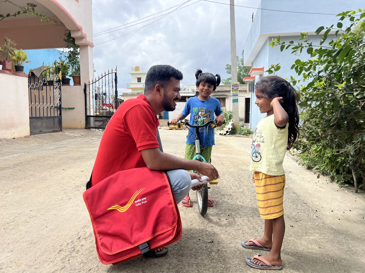 IndiaPostOffice's tweet photo. Some conversations are more than words, they’re little moments of connection. ❤️

Meet Rakshith Kumar K A, ABPM, Sakalawara BO, Karnataka. For him, every doorstep brings a story, a smile, and sometimes, a few curious little faces that make the journey worthwhile.

Through winding roads, changing terrains and the everyday challenges of the route, he keeps moving forward - because every address matters.

Beyond the familiar roads lie remote communities, where a visit from the postman means more than just a delivery.
