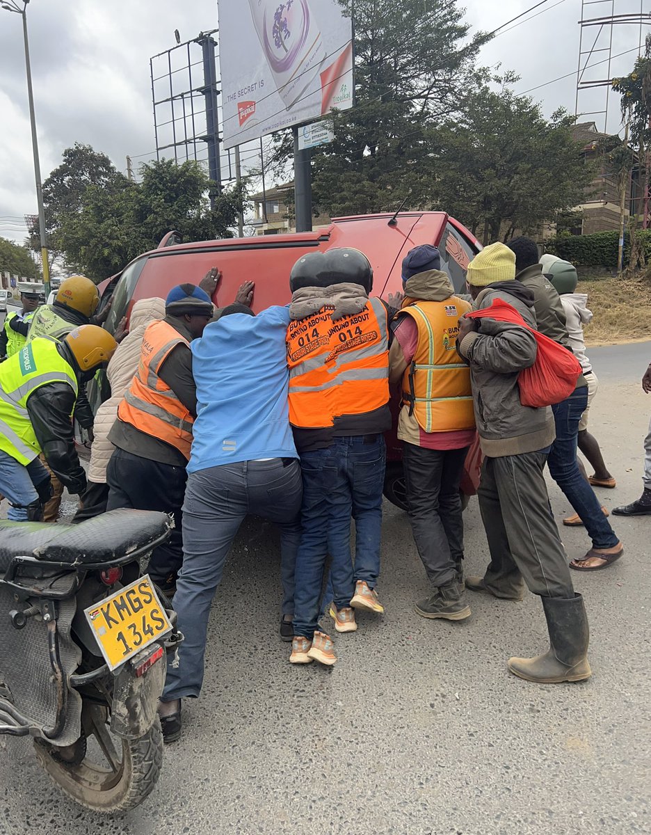 KLomenenE's tweet photo. Jamaa wa hii gari alipiga “soma” pale Bunyala Roundabout! 

Hawa jamaa hawakutaka story mingi waliona gari imekwama wakaamua, “Wacha tuiinue tu!” 💪🏽😂

Gari wakaleta chini kama kitu ya kubeba kwa mkono! 

Teamwork ya ukweli. 😂 https://t.co/u8ZlTyocQR