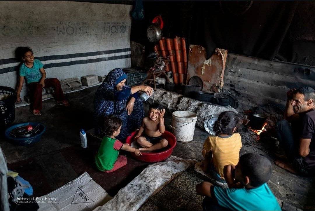 EsleemRoba456's tweet photo. In war-torn Gaza, a mother tries to ease the intense summer heat for her children in their tent, using the small amount of water available to cool their bodies amid soaring temperatures.

#TheyLiedToYou #they_lied_to_you #كذبوا_عليكم https://t.co/2RXXBn4nop