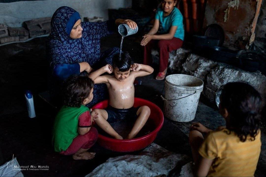 EsleemRoba456's tweet photo. In war-torn Gaza, a mother tries to ease the intense summer heat for her children in their tent, using the small amount of water available to cool their bodies amid soaring temperatures.

#TheyLiedToYou #they_lied_to_you #كذبوا_عليكم https://t.co/2RXXBn4nop