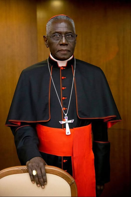 trad_west_'s tweet photo. >Be Cardinal Robert Sarah
>Born in a remote village in Guinea, raised by his devout catholic his parents and local missionaries
>Becomes an Archbishop at just 34 years old in the middle of a brutal Marxist dictatorship
>The dictator, Touré, literally puts him on a death list; Sarah doesn't run, and keeps preaching the Gospel
>Touré died unexpectedly of a heart attack in March 1984, just weeks before the planned executions
>Becomes one of the sharpest, most fearless defenders of traditional Catholic faith in the modern era and is made a Cardinal
>Looks at secularized West and warns us: "If Christianity disappears in Europe, the whole world is threatened."
>Writes absolute masterpieces like The Power of Silence
>Delivers banger quotes like: "The West has denied its Christian roots, a tree without root dies"
>"As a bishop, it is my duty to warn the West! The barbarians are already inside the city."
>Keeps telling europeans to have more babies

Unfathomably based