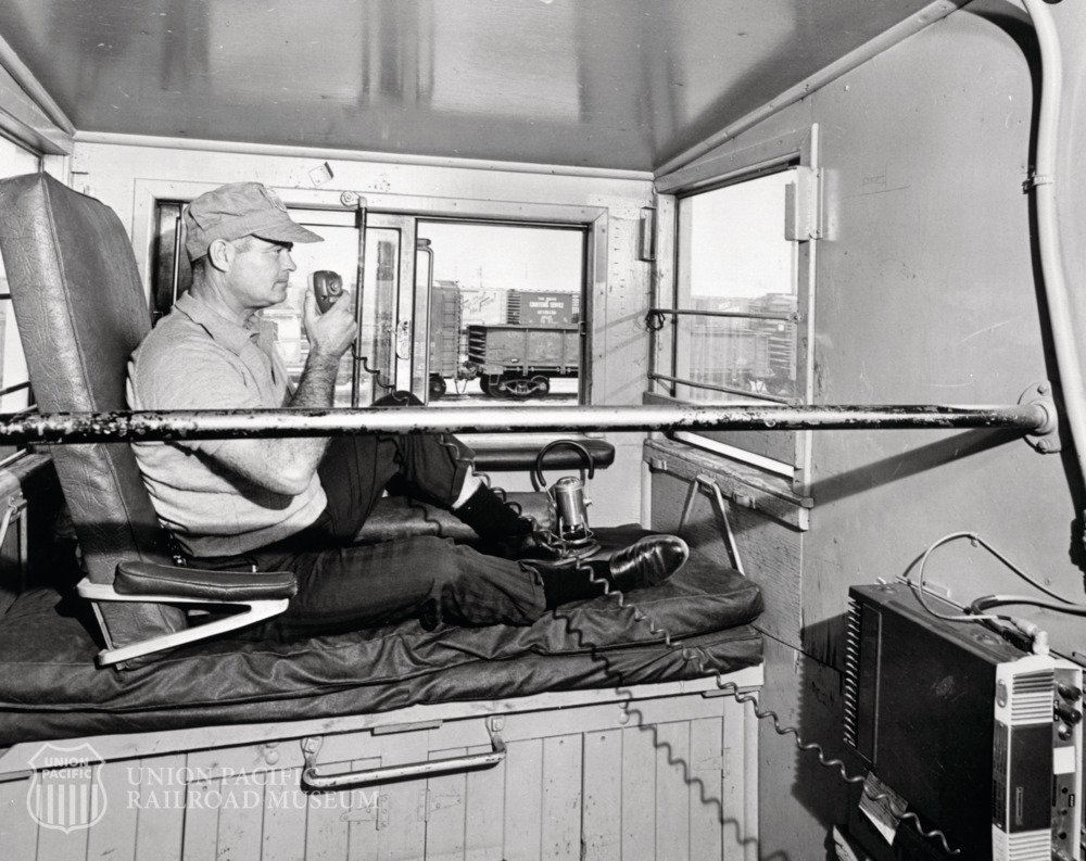 UPRRMuseum's tweet photo. A conductor uses the radio perched in this unusual caboose. Who knows the model? Whatever it is, they had a great view! https://t.co/exgNhUnVam