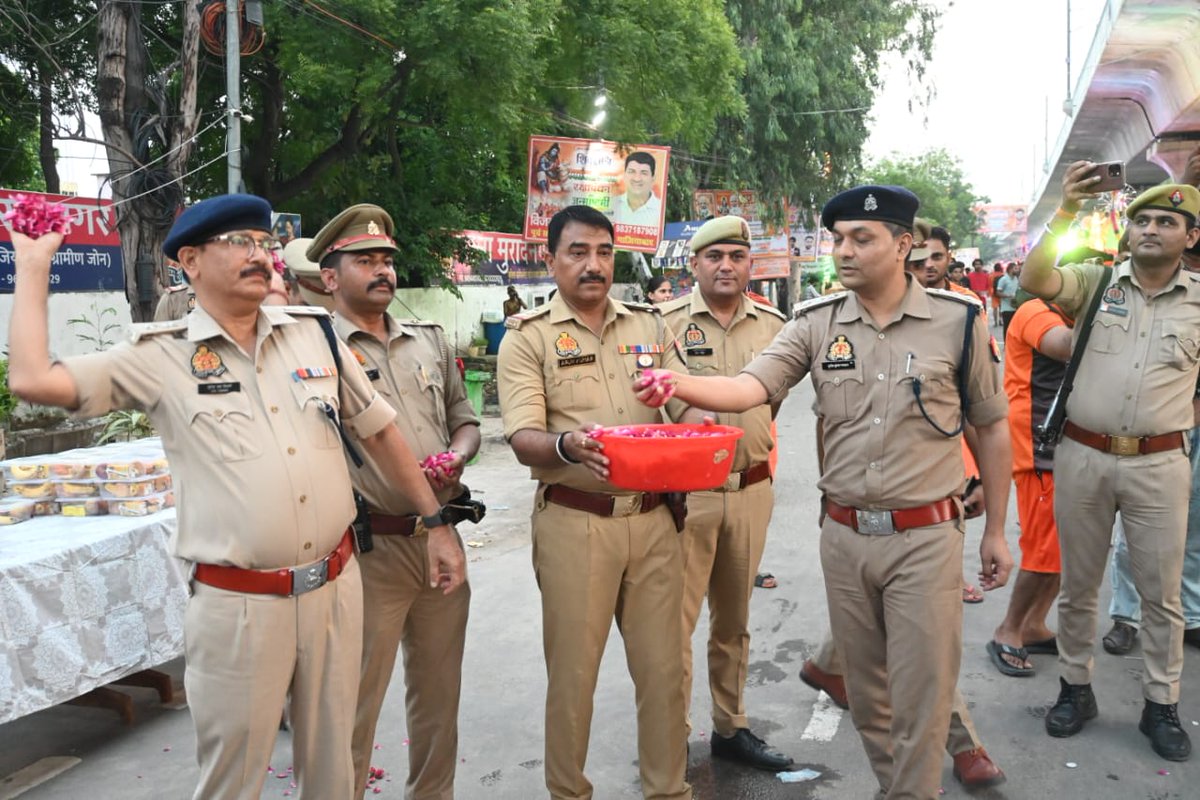 ghaziabadpolice's tweet photo. श्री सुरेन्द्र नाथ तिवारी, पुलिस उपायुक्त ग्रामीण कमिश्नरेट गाजियाबाद द्वारा पुलिस बल के साथ थाना मुरादनगर क्षेत्रान्तर्गत कांवड़ यात्रा-2026 के दौरान शिवभक्त कांवड़ियों पर पुष्पवर्षा कर उनका भव्य स्वागत एवं अभिनंदन किया गया तथा शिवभक्तों को प्रसाद वितरित कर उनकी श्रद्धा एवं आस्था का सम्मान किया गया। इस दौरान शिवभक्तों के प्रति सम्मान एवं श्रद्धा व्यक्त करते हुए कांवड़ यात्रा के सकुशल एवं शांतिपूर्ण संचालन हेतु पुलिस बल द्वारा निरंतर सुरक्षा एवं व्यवस्थाएं सुनिश्चित की गईं।
@Uppolice