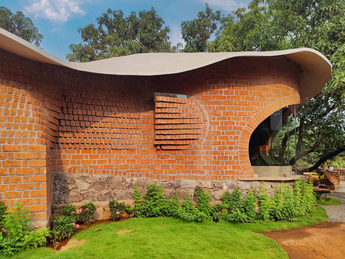 shavnyuyngah's tweet photo. This is what happens when a fabricator, a ferrocement contractor, a structural engineer, and a landscape architect all know their craft at a specialist level.

Asmalay, in Alibag near Mumbai, curves around five mango trees instead of cutting them down. The roof is ferrocement, shaped by hand to follow the canopy. The walls are rat-trap bond brick, a technique that insulates and saves material at once. A staircase wall is set with hundreds of recycled glass bottles, each one placed to catch light exactly where it lands.

None of this happens without skilled trades. Not architects alone, but the fabricator who could actually bend that roofline, the contractor who understood ferrocement, the mason who could lay a curved brick jali without it collapsing.

This is exactly why I keep pushing for vocational and technical education across the continent. Design vision means nothing without hands trained to build it. We have the ambition. We need the skill to match it.

Design: Prashant Dupare, Shriya Parasrampuria, Archiit Chatterjee
Fabricator: Amit Thanekar
Civil Engineer: Mahesh Patil
Structural Engineer: Himanshu Tulpule
Ferrocement Contractor: Sunil Gade
Location: Alibag, Maharashtra, India
Built area: 2,000 sq. ft.
Completed: 2023