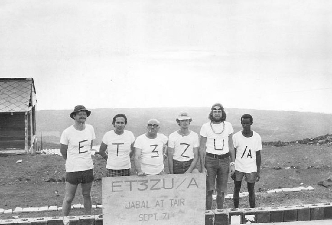 DX_World's tweet photo. Jabal at Tair is a deleted DXCC entity in amateur radio. It's a volcanic island near Yemen.

It was included in the ARRL DXCC country list starting from November 15, 1945, but later removed and placed on the Deleted DXCC Entities list.

Original image alongside AI enhanced "modern day".