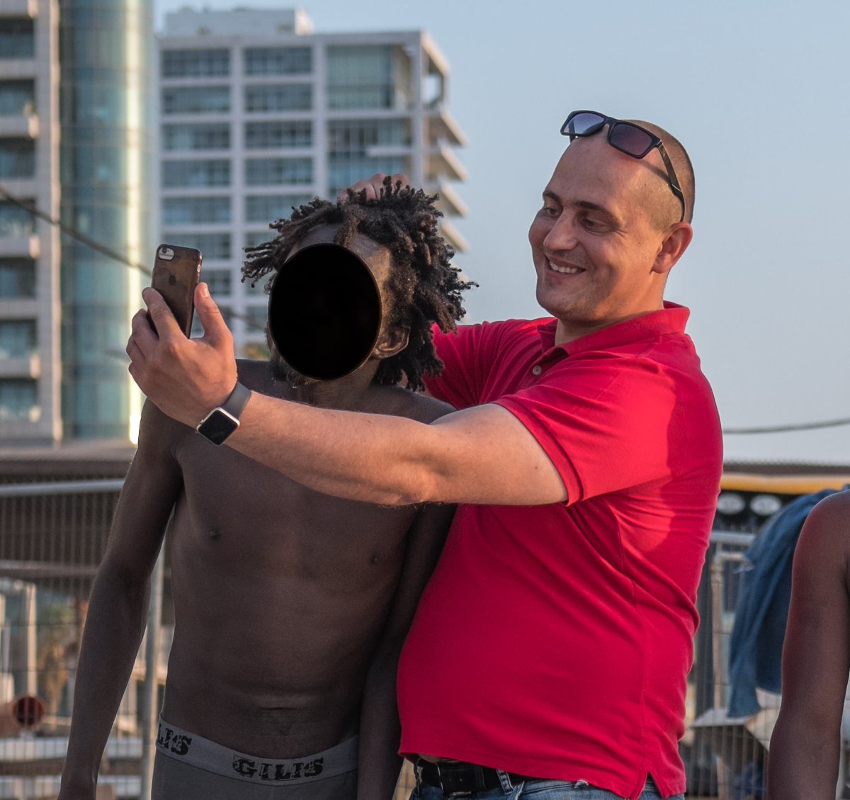 DaniMayakovski's tweet photo. Vean como un colono sionista humilló y denigró a un joven negro etíope solo porque estaba usando las duchas de la playa de Tel Aviv, el sionista lo agarra por el pelo como si fuese un animal y lo obliga a posar con él.

Esta es la cara real del sionismo y su sociedad colonial. https://t.co/Akbo4WwRT3