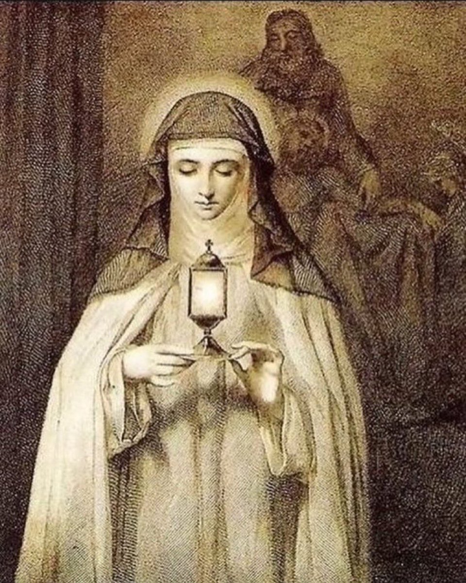 BreeSolstad's tweet photo. April 15, 2023:  I was in Assisi. I knew very little about Saint Clare. I was still producing porn and was really just in Italy for fun and for art appreciation.

I entered her basilica and went down the stairs to her crypt. I checked out all her relics and then got to her tomb. I knelt by her tomb just like everyone else was doing. 

I am not a mystic and I have never experienced anything like this before but, in an instant, Saint Clare was actually present with me. She was dressed in a beautiful gown that looked like a dress a bridesmaid would wear and her face was obscured by a magnificently bright light. She showed me her heart, her soft arms and her lap, and was imploring me that it was a place where I could lay everything down. 

She told me that she was going to take all the pain and anxiety from me and somehow give it to God. I felt deeply that she was telling me that I could count on her and that I could trust her and Jesus with my heart. I cried, but also felt peace for the first time in a long time. This was the first major step in my conversion.

In the moments after this happened, I didn’t know what to do with it or think about it. It took a long time for the supernatural power of this moment to really sink in with me.

When I returned from Italy, I was at a grocery store restocking my kitchen after my trip. I pulled a box of cereal off the shelf and sitting right there behind it was a Saint Clare of Assisi prayer candle. I don’t know how it got there but it struck me like a thunderbolt. I purchased it.

Months later, as I was reading more and more about the life and impact of this great Saint, I read a first hand account written by a nun. She also had a mystical experience with Saint Clare and her experience shook me to the core. Her description of what she was matched mine. The nun wrote about Clare wearing a beautiful gown, about her face being obscured by white light, about her showing her forearms and her lap. It blew my mind!

Saint Clare of Assisi, on this your historical Feast Day, I honor and praise you and thank you for reaching out to me and making yourself present to me.  I know God worked through you to get me to understand that I didn’t have to suffer alone and needed to come home to Jesus.  I love you.