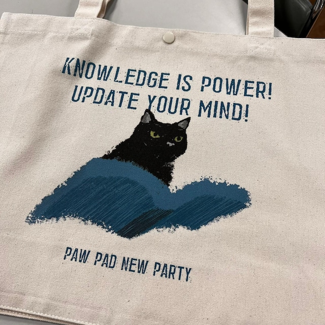 cat_pad299's tweet photo. #肉球新党 グッズショップでは、8/9（日）～16（日）まで、Tシャツ・トートバッグ等の販売受付を行います。発送は8/22（土）の予定です。

　今日のおススメは「本猫」。
　トランプや高市など、世界中を席巻する排外主義や自国第一主義によって民主主義がキケンな状況にさらされていますが、その根底にあるのが「反知性主義」かもしれません。それに対して肉球新党は、「知は力なり」を対置します。

　過去を知り、現在を知ることは、未来を語るうえで必要です。そのためにエンパワーメントをすること、知識をアップデートすることは、寝ることに次いで大切です。

　このデザインは、本という知性の翼に乗って自由に空を飛び回る黒猫さんがモチーフ。
　このデザインには、通常のコットン製のTシャツ、ドライ版のTシャツに加えて、トートバッグもあります。

【コットン製のTシャツ】
https://t.co/4DPbXcAaAw

【ドライ版のTシャツ】
https://t.co/DHVvLNOXy3

【角底トートバッグL】
https://t.co/hlQIVFwf9C