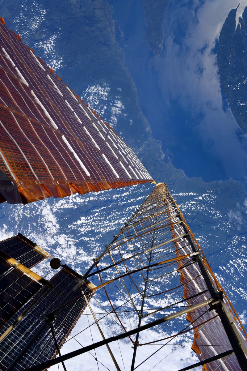 Astro_Jessica's tweet photo. While I wasn’t gazing at @astro_anil during last week’s spacewalk, my eyes were drawn downward to our majestic Mother Earth.  Here’s how she looked from my spacesuit.
Photo 1: Coastal view framed by the @Space_Station solar arrays.
Photo 2: The sun sets behind our newly installed IROSA mod kit, a mounting platform for new arrays to be installed on an upcoming spacewalk (like the shorter array in lower left of photo 1).
Photo 3: Mountain views framed by the @Space_Station  solar arrays.
