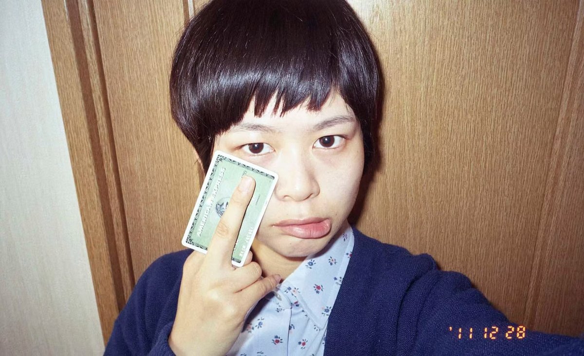 tomo_kosuga's tweet photo. 【#ツイートで語る世界の写真家たち〈８〉】
2012年、高木美佑は成人を迎えるまでの100日間をフィルムで撮影し続けた。ここで彼女が試みたのは、社会的コンテキストの前に自身の姿を置くということだ。セルフィの要領で、成人するまでのモラトリアム期を記録する。
青年期が抱える理想のイメージとは裏腹に、日々を淡々と「つまらなく」記録し続けること。この世に生まれ、逃れられない時の流れの中で生きること。高木は、そうした負の視点をどこかユーモラスに描いた。

「私にとって大人になるということは悪であり、恐怖でもありました。どうにかして私の十代を記憶に残そうと、二十歳の誕生日までの百日間を24枚撮りカラーフィルムで１日１本撮影しました」
高木美佑『しょーもない私の十代が終わりました。』ステートメント（2012）

注視すべきは、彼女が自らの十代を「しょーもない」と切り捨てながらも、その一方で必死に保存しようとしていることだ。大人になることへの恐怖が期待を上回る中で、失われゆく少女時代をフィルムに定着させ続けた。

毎日を撮ることの反復は、否応なく「今を生きる」という現実を語り、写真に独特の厚みを与える。さらに言うなら、ここに映る少女はまだ、成人した後の自分を知らない。大人になることへの焦りと不安を抱きながらも、その先がどんな体験であるかを知らないのである。
だからこそ、写真に描かれた彼女の「オトナの試み」はどこかぎこちなく、偏見やズレを孕んでいる。しかし実態との距離があるからこそ、フィルムに焼き付いたジュブナイルな日々は いっそう輝きを増す。

後年話題になった『100日後に死ぬワニ』のカウントダウン構造を引き合いに出すまでもなく、高木ははるか前に自分自身を題材として同じ構造をやり遂げていた。彼女は決して物理的な死を題材にしていたわけではない。しかしそこには「自分のなにかが失われる」という強い喪失の予感があった。
100日後に必ずハタチになるという宿命の下、高木はフィルムという不可逆的なメディウムを直感的に手に取ったのだろう。

時の経過と共に訪れるいつかの「答え合わせの日」、写真は単なる記録の役割を脱ぎ捨てる。撮影者の肉体と時間が交差する場所で、それは独立したひとつのリアリティとして立ち現れるのである。

高木美佑さん @2h35m 
https://t.co/YVej7Xg71c