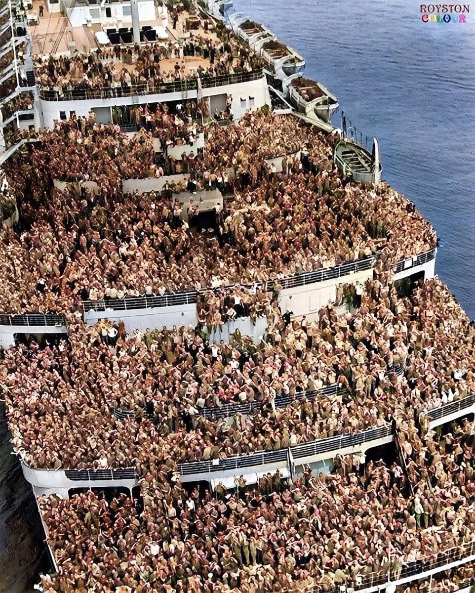HiddenHistoryYT's tweet photo. 11 August 1945
"US troops on an ocean liner, returning to New York harbor at the end of World War 2"

This is the RMS Queen Elizabeth pulling into NewYork with returning US Servicemen in 1945

She sailed from Gourock in Scotland on August 6 1945 arriving at New York on August 11 1945.
Some of the servicemen could therefore be Ground Echelon of 492 Bomber Group.

The Queen Elizabeth together with the Queen Mary were used as troopships in the Second World War. Their great carrying capacity and speeds of over 28 knots were a huge asset to the Allies. The Queen Elizabeth, (carrying capacity over 15,000 troops and over 900 crew), was to carry 750,000 troops in total and she to travel over 500,000 miles.