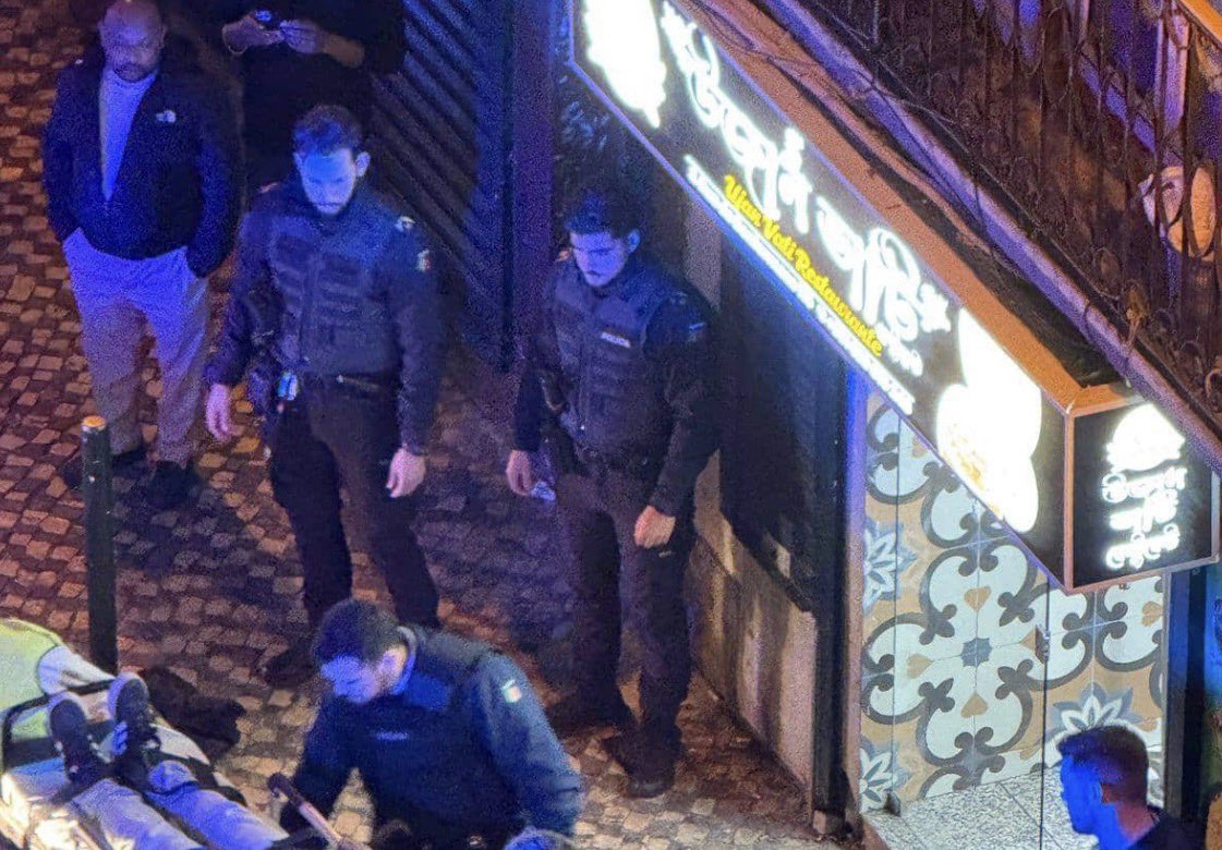 visegrad24's tweet photo. BREAKING:

The Swedish female tourists who was shot in central Lisbon by drug gangs will survive according to a new statement by her doctors.

The 42-year-old was shot in Lisbon’s central Baixa while buying pastéis de nata. A conflict between two gangs involved in street-level dealing of fake hashish (pressed bay leaves sold to tourists as cannabis) broke out and shots were fired.

The Swedish woman was hit in the chest by a stray bullet and her condition was initially life-threatening. Doctors now say that’s she’s out of danger.

A man, already known to police for selling fake hash to tourists and several domestic violence cases, was identified via CCTV and arrested at his home. A shotgun was seized there, but the actual firearm used in the shooting has not been recovered. 

After an initial hearing he was released with conditions requiring him to report to a police station twice a week. 

Lisbon Mayor Carlos Moedas publicly criticized the court’s decision as “unacceptable.”

🇵🇹🇸🇪