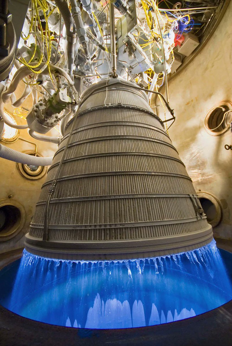 Arkasiraee's tweet photo. A liquid rocket engine has a problem that seems almost impossible to solve, its combustion chamber can contain gases approaching 3,000-3,300°C, while the metal containing them would rapidly lose its strength at those temperatures. 

The solution is remarkably simple in principle and extraordinarily difficult in execution. The cryogenic propellant itself becomes the coolant to remove the heat from the metal. 

In an engine such as SpaceX's Raptor for example, cryogenic liquid methane, whose normal boiling point is about -162°C, is forced through precisely engineered passages built into the chamber and nozzle walls before reaching the combustion system. 

The fuel absorbs heat from the metal while flowing through a microscopic heat exchanger that is effectively manufactured into the engine itself. Near the throat, heat flux can exceed 10 MW/m², making this one of the most demanding thermal environments in propulsion.

The complexity is in controlling thousands of tiny flow paths simultaneously. Their size, spacing, wall thickness, surface finish and flow resistance determine how evenly heat is removed. 

Too little cooling in one region creates a local hot spot, a restriction, void or dimensional defect can reduce coolant flow precisely where the heat load is highest. 

The sequence can become catastrophic, reduced cooling leads to rising wall temperature which then causes material weakening and deformation, which then creates further disruption of the cooling flow and  burn-through where the nozzle fails.  

That makes the materials and manufacturing process inseparable from the thermal design. 

Highly conductive copper alloys such as GRCop-42 have been developed for high-heat-flux chambers, while modern additive manufacturing can create intricate internal cooling geometries that are extremely difficult to reproduce conventionally. 

Meanwhile, large engines move extraordinary quantities of propellant, Vulcain engine, for example, processes roughly 235 kg of propellant every second, including about 41 kg/s of hydrogen through its engine system.

The real manufacturing constraint is therefore not simply making a rocket engine withstand extreme combustion temperatures and pressures. 

It is manufacturing a pressure vessel whose walls efficiently contain a precision heat exchanger, distributing enormous propellant flow exactly where the heat is trying hardest to destroy it and doing so reliably every time the engine fires under immense pressures.
