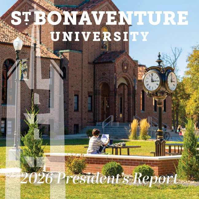 Student studying outdoors near a historic brick building and vintage clock on St. Bonaventure University campus.