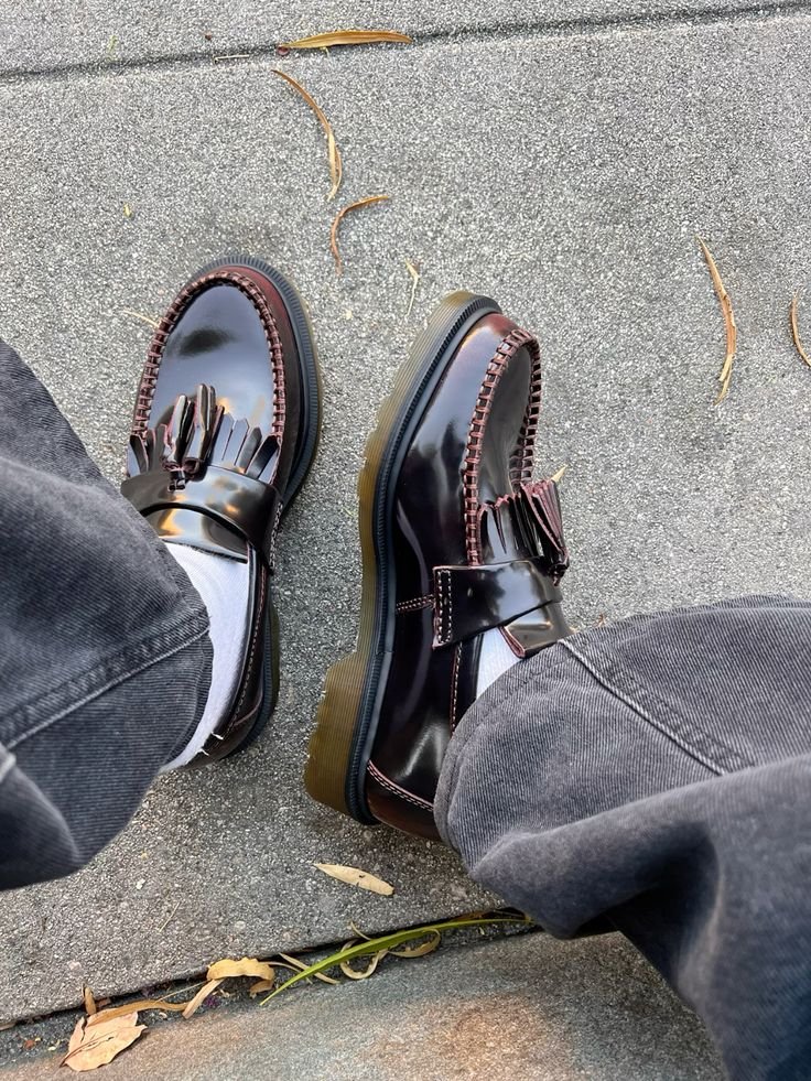 Navy trousers, a cream crew sock, and brown loafers under autumn trees, posted on X by @TheModernLegacy