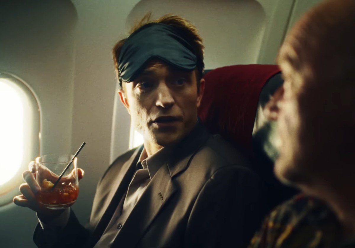 Alcoh0ltwt's tweet photo. As an alcoholic, I’m very interested in knowing what Pattinson is sipping on here. The only cocktails that are red like that are the Negroni and its various riffs, but who serves a Negroni over ice like that and what airline serves a Negroni in the first place? #Primetime https://t.co/429y16xzAj