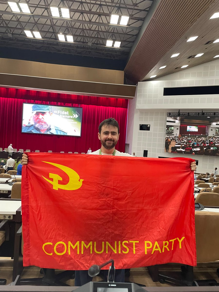 CPBritain's tweet photo. "This picture was taken today, on day 3 of the First International Colloquium of the Centenary of Comandante Fidel Castro in Havana.

I have attended as part of the Assata Shakur Brigade to bring practical solidarity and 20 suitcases of vital supplies to support the Cuban Revolution against the genocidal US blockade.

The barbarism of the imperialists I've witnessed here does not come as bombs from the sky, but as the preventable deaths of thousands of infants in hospitals across this nation. This is the direct result of the blockade, a policy of murder carried out by the monsters in Washington DC.

I look forward to returning to Britain to continue the vital work of defending this revolution at home, as part of my Party, my brigade and the Cuba Solidarity Campaign. This is the responsibility of every communist in Britain, and of every friend of peace, sovereignty and the struggle for socialism worldwide."

- Comrade Ben W, SE London Branch, reporting from Cuba.