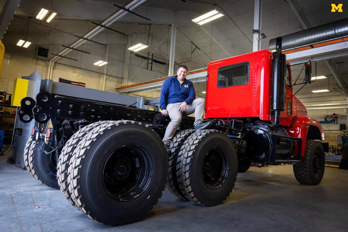 Dave Stockoski poses on the chassis of a Freightliner M916 six-wheel drive truck that is converted into a large fire engine.