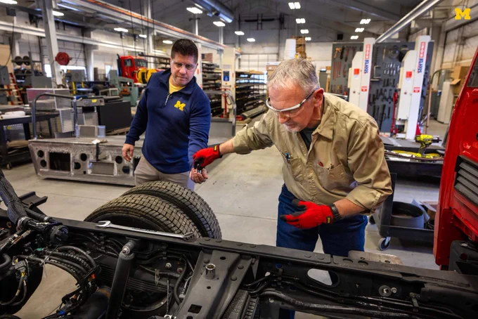 Dave Stockoski (left) and Ray Delaney work on the exposed chassis of a fire truck.