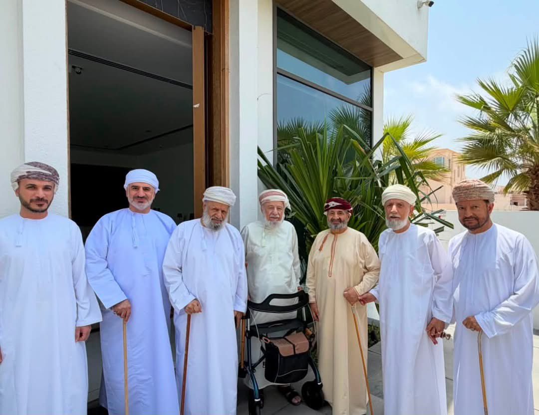 AlsiyabiHamood's tweet photo. ذات دخول من "دروازة كشام" في العذببة للقاء أحفاد فارس الشرفا
——————————
 حمود بن سالم السيابي 
——————————
يبدو أن لحديث مقهى "رونكالي" في هامبورج تتمة ، فالدلال لم تبرد بعدْ.
ولا الفناجين ثملتْ من عبق الهيل. 
ولا ابتسامة النادلة انطفأتْ وهي تلملم ثمالة الحكايات.
ولا مستظلّ جلستنا عاندَ الشمس ، ولا حماس أغصان شجر الأرصفة فتَرَ عن التأرجُحْ.
والسرد الذي بدأناه في المقهى الهامبورجي ما زال يتدافع فصلاً تلو فصل ، وقد اتسع هذا النهار لوجوه كريمة تضيف للجلسة البهاء ولدوران الفناجين شهية "التغنيم". 
نحن في "العذيبة" العذبة فحيث "يحمدها الحرث الكرام" هناك دوماً المنهل العذب والوِرْد الأصفى.
وحيث يغرس أحفاد "فارس الشرفا" الرمح هناك "بيت البرج" وفلج المضيرب:
"بحرُ المكارمِ غوثُ الخلقِ من شملتْ
للكونِ من برِّهِ رحمى وإحسانُ"

والدخول إلى ديارهم  يتم عبر "دروازة كشام" ، فأينما حلُّوا كانت بيوتهم مدنا وأبواب بيوتهم "دراويز".  
وقد أنصفهم شاعر العرب:

"يبلى الزمان ولا تبلى محامدكم
ما دام يحمد مطعام ومطعان"

وفي صبيحة الثالث عشر من أغسطس ٢٠٢٦ زمَمْنا الأحصنة باتجاه "دروازة كشام" في العذيبة يتقدمنا سيدنا الهلال السيابي وقد مشينا خلفه وحادينا قوافيه.
وكان في المسير الشيخ العزيز الدكتور عبدالعزيز بن سليمان بن خلف الخروصي والشيخ العزيز إسحاق بن سالم السيابي. 
وعند "دروازة كشام" في العذيبة احتوتنا هيبة المداخل فاستشعرنا قدوم "الأسد الكرار" الشيخ سليمان بن حميد الحارثي فهذا السطوع لون صُبحه. 
ولم تخطئ ظنوننا حين تلفتنا يمنة ويسرة نترقب دخول صفي الإمام الرضي الخليلي والسلطان سعيد بن تيمور الشيخ حمد بن سليمان الحارثي فما أجمل الانصات للتاريخ بلسانه صناعه. 
وكان في "بيت البرج" بالعذيبة المشايخ إبراهيم وزاهر وأحمد أبناء الشيخ حمد بن سليمان الحارثي وأنجالهم الكرام ، وقد أفسحوا أمكنة بين كل كريمين لجلوس الجد فارس الشرفا والأب حمد ، ليتصدرا الجلسة وإن غابا فلهما الرطبة الأولى والفنجان الأول ، وبهما يستفتح الحديث. 
ومن التوافقات أن لقاء "هامبورج" قبل ثماني سنوات كان زمن الرئاسة الأولى لرونالد ترامب ، بينما لقاء "العذيبة" يجيء زمن ترمب أيضا في رئاسته الثانية. 
وبين الرئاستين كانت قصيدة سيد القوافي الهلال السيابي والمرسلة منه لحفيد فارس الشرفاء في نوفمبر ٢٠١٨ استشرافة الشاعر للحالة العربية زمن الرئا��ة الأولى لترمب ومآلات الحواضر العربية زمن رئاسته الثانية ، إذْ غاصت القصيدة عبر ستة وستين بيتا في تشريحها الموجع للحالة العربية من البحر إلى البحر. :

أنَّى تلفَّتُّ لم أبْصِرْ سوى جدثٍ
بالٍ  ولمَّا أشاهدْ غير ذي خبلِ

ولستُ أبصرُ إلَّا مايسوء ولو قد 
كان عرساً ، فذاك العرس من دخَلِ

أنَّى مشيتُ أرى عنوانَ مخزيةٍ
أو شرْحَ كارثةٍ شوهاء بالعللِ

حتى أقول لنفسي : أين ما نقلوا 
عن الأعاظم من قولٍ ومن عملِ  

أين الألى  ذكر التاريخ وصفهم 
بكل ذكر مجيد الحلي والحلل

وأين من عظَّمَ القران نعُتَهُمُ
بأنهم خير أهل الأرض للأزل

أنحن أبناؤهم ورَّاث مجدهمُ
أم كل ذلك تخييل من النقل؟

 فليت شعري مالي لا أرى أبدا
 ماقيل من قصص عن تلكم الأُوَلِ

مالي وحقك لا ألقى سوى خبل
أو كل مستضعف هيَّابةٍ وكِلِ

 مابال قوميَ بعد العز قد ركبوا
متن المذلة ، ما أقساه من خطل !!

لم يبق من عزهم أو من مكانتهم 
إلا تحذلقهم عن ذلك البطلِ

في كل يوم لهم خطب وكارثة 
أقسى على المجد والتاريخ من كبلٍ

وقد طاف اللقاء بالأوضاع في فلسطين والخليج والشام ومصر قبل أن يرسى الشراع على مرافئ الأمان عمان فأثنى الشيخ إبراهيم الحارثي على النهج الذي اختطته عمان بحكمة قيادتها الرشيدة فأثبتت الأحداث صواب النهج وصحة المسار. 
وساق الشيخ زاهر الحارثي ذكرياته مع سيدنا الوالد في مسجد الرضا متحدثا عن جرأة العالم الذي لا يخاف في الله لومة لائم. 
وسرد الهلال مواقف شبيه الصحابة الشيخ العلامة سعيد بن حمد الحارثي كما تجلَّتْ في كتبه وأحاديثه. 
واستدعى الشيخ أحمد الحارثي أيامه السمائلية في مسجد الشيخ العلامة خلفان بن جميل صحبة أخيه الشيخ العلامة سالم بن حمد الحارثي. 
وفيما أذان الظهر يوشك أن يرفع خرجنا من "دروازة كشام" لنفسح لقوافل جديدة على وشك أن تخب ودلال قهوة "بيت البرج" تست��جل دوران الفناجين ، بينما الذهن يستعيد أبيات قصيدة سيد القوافي الهلال في تراسله الأخوي مع حفيد فارس الشرفاء:

يا زاهر المجد يا ابن الغر من مضر
وابن الضراغم والخطية الذبلِ

لئن بعثتَ إليّ اليومَ  مألكةً 
فذاك من كرم الأخلاق والنبلِ

وليس من عجب أن ينحني غصن
لذاته خافق الأنفاس من جذلِ

حَيْيتني بتحيات مطيبةٍ
أحلى من الكاس بل اشهى من العسل

لكن أتتْني وأضلاعي تمور أسى 
والنفس من برحاء الخطب في شغلِ
—————————
مسقط في ١٣ أغسطس ٢٠٢٦م.