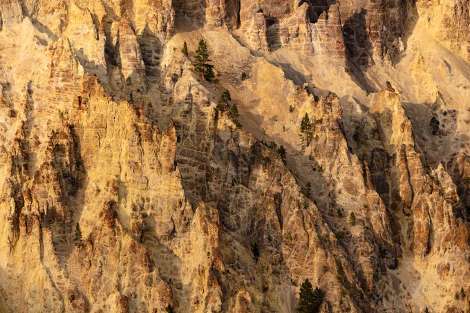 A close-up of the multi-hued orange/yellow-colored rocks on the steep canyon walls.