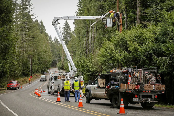 Crews in a bucket truck work on repairs