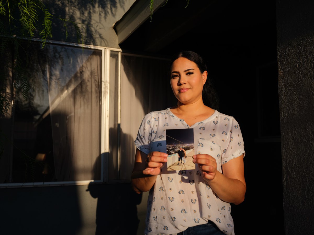 bencamach0's tweet photo. The lead image: Mayra holding a printed photo of her and Mike on a trip they took together in the past. https://t.co/9XrNHcJYqh