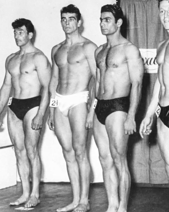 GustavoAdolf_'s tweet photo. Sean Connery participó en el certamen de Mr. Universo de 1953 representando a Escocia🏴󠁧󠁢󠁳󠁣󠁴󠁿,
Connery compitió en la división de "Talla Alta" (Tall Class) de la sección de aficionados y logró la tercera posición (medalla de bronce). El concurso de Mr. Universo de ese año lo ganó el estadounidense Dick DuBois 🇺🇸.
Aunque no ganó el título principal, su paso por el certamen celebrado en Londres fue decisivo. Durante su estancia, se enteró de que se estaban haciendo audiciones para el musical South Pacific. Se presentó, consiguió un papel en el coro y fue ahí donde decidió abandonar definitivamente el culturismo para volcarse de lleno en la actuación. Unos años más tarde, esa misma presencia física y elegancia le abrirían las puertas para convertirse en el James Bond más icónico del cine.
Mito.