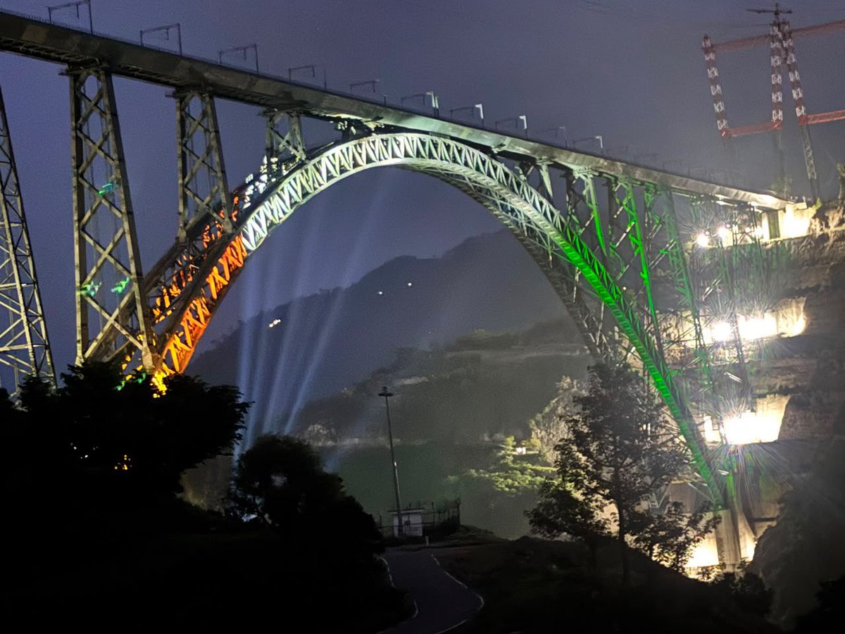 RailMinIndia's tweet photo. A marvel of Indian engineering, glowing in the colours of our national pride. 

The nation's Pride Chenab Rail Arch Bridge shines in tricolour on the Independence Day eve.🇮🇳

#IndependenceDay #ChenabBridge https://t.co/U5pnvpaVQb