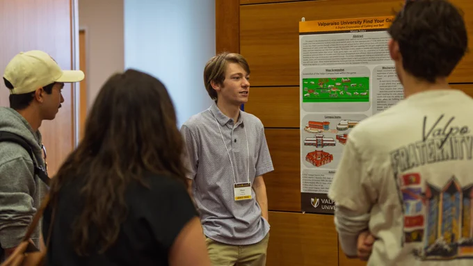  Valparaiso University computer science alumnus Mason Tulacz ’26 presents his work for Valpo FutureQuest on a posterboard.