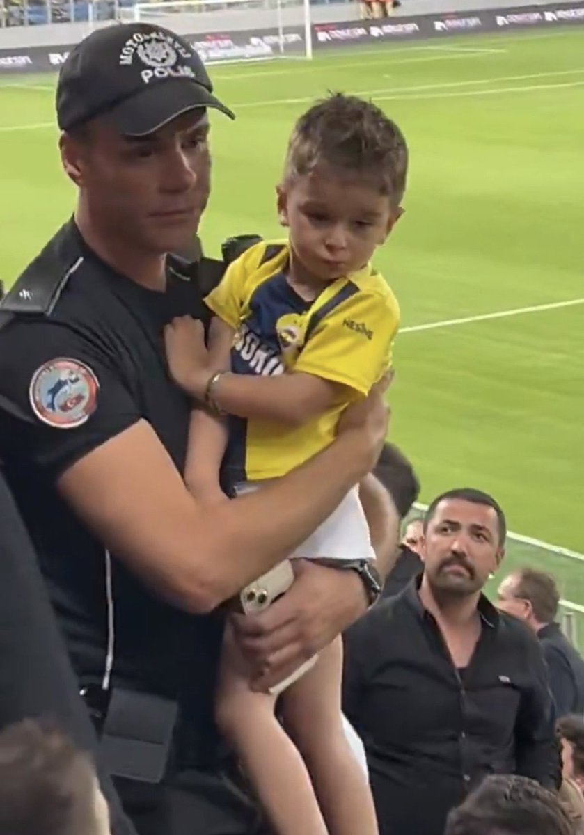 bilio_muydunuz's tweet photo. Gençlerbirliği - Fenerbahçe maçı öncesi Ankara ekibinin taraftarları, Fenerbahçe formalı minik taraftara tepki gösterdi ve formasının çıkarılmasını istedi.  
Taraftarların arasından minik kardeşimizi alan bir polisimiz, kardeşimize polis tişörtü giydirerek baba oğulu daha rahat maçı izleyebilecekleri bir yere aldı.