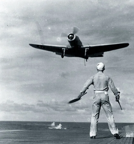UntoldWarFacts's tweet photo. Landing a propeller aircraft on a carrier meant approaching nose high, with the aircraft itself blocking most of the pilot's view of the deck ahead.

So he looked to the side.

Standing on a small platform at the edge of the flight deck was one man holding two paddles.

He was one of the last things between a safe landing and a catastrophe.

This is the story of Paddles..🧵1/4