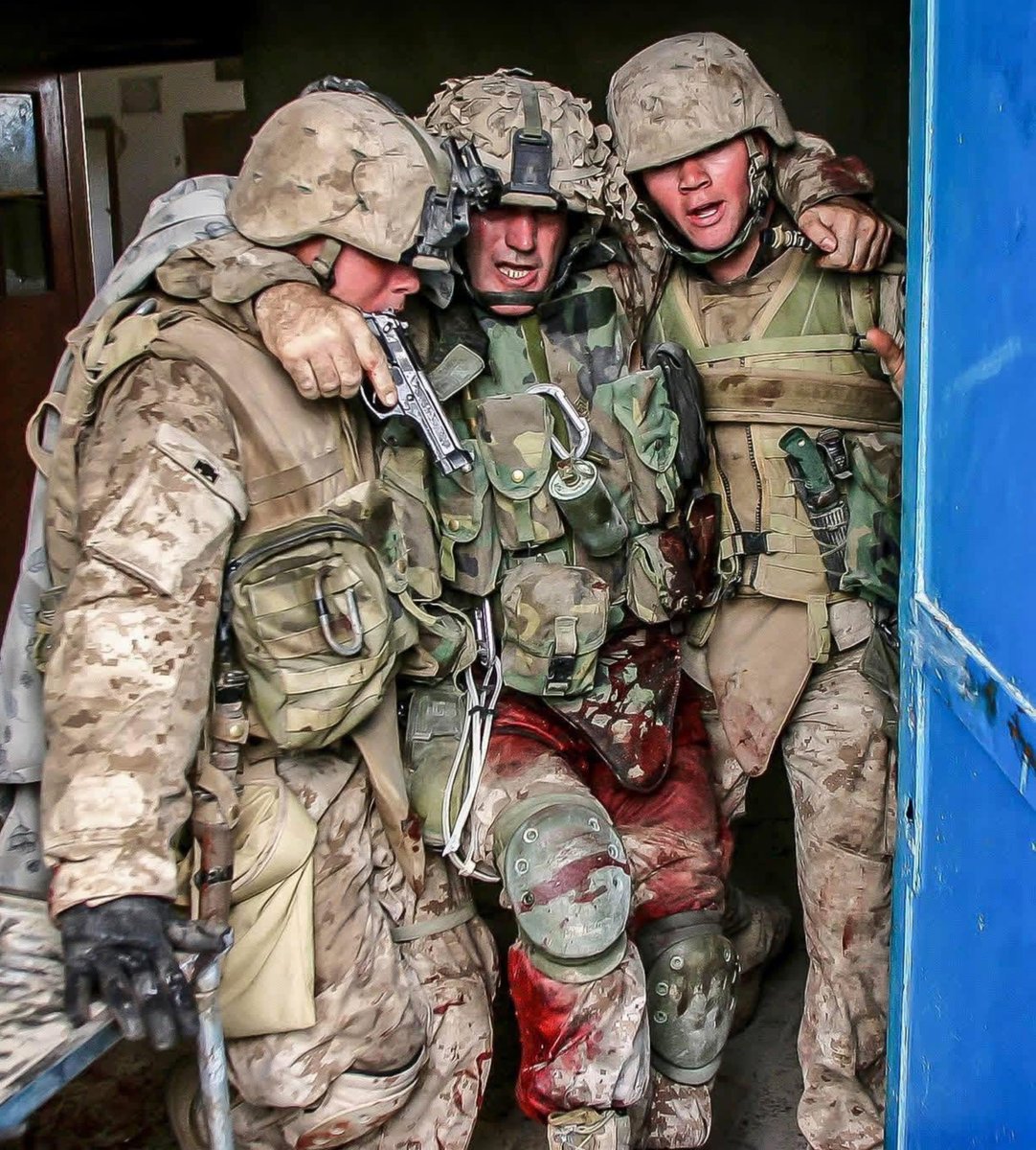 specialopsmag's tweet photo. Among the most unforgettable images of the Iraq War is the photo of 1st Sgt. Brad Kasal being helped from Fallujah’s “Hell House” by LCpl Chris Marquez and LCpl Dane Shaffer on November 13, 2004, during the Second Battle of Fallujah. 

Blood soaked and still clutching his 9mm Beretta, Kasal became a lasting emblem of sacrifice and the bond between Marines. Inside the house, he had been shot by insurgents 7 times and hit with shrapnel from a grenade blast after he threw himself over a wounded Marine. Gravely wounded and bleeding heavily, he still refused to be pulled out until the rest of his men were accounted for.

Those actions earned 1st Sgt. Brad Kasal the Navy Cross. The picture, and what he did that day, stand as a clear expression of the Marine Corps ethos: courage under fire, loyalty to one another, and the refusal to leave a fellow warrior behind.