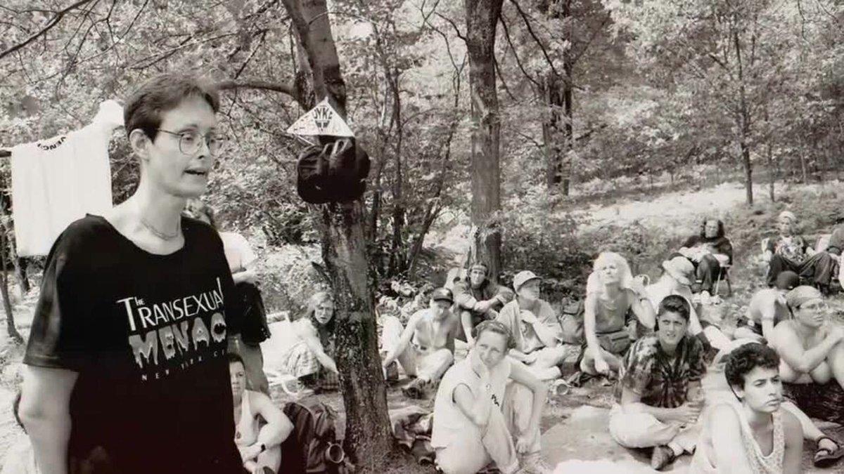 Shattubatu's tweet photo. Michfest, the biggest lesbian festival in the US, banned trans women for its entire 40-year run under a "womyn-born-womyn" policy. Trans women set up Camp Trans outside the gates for two decades asking to be let in. The festival chose to die in 2015 rather than admit them. https://t.co/zei3uk65TE
