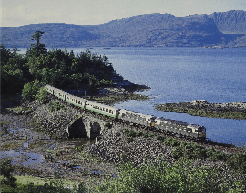 TheRailHub's tweet photo. Reminding us of the many years when six-cylinder Birmingham RC&amp;W diesels held sway in the Scottish Highlands, Nos. D5301 and D5300 clatter across the causeway at Craig Highland Farm, Duncraig, by Loch Carron with the 17.05 Kyle of Lochalsh-Inverness on 25 August 1993. https://t.co/29TB0ZXQHo