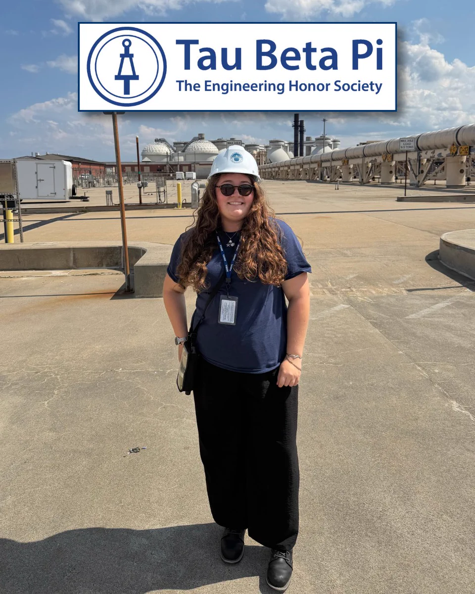 A person wearing a blue hard hat and sunglasses stands on an industrial rooftop. They are dressed in a blue shirt and black pants, with a lanyard and badge. In the sky, the logo for "Tau Beta Pi: The Engineering Honor Society" is displayed. The background features industrial equipment and clear skies.