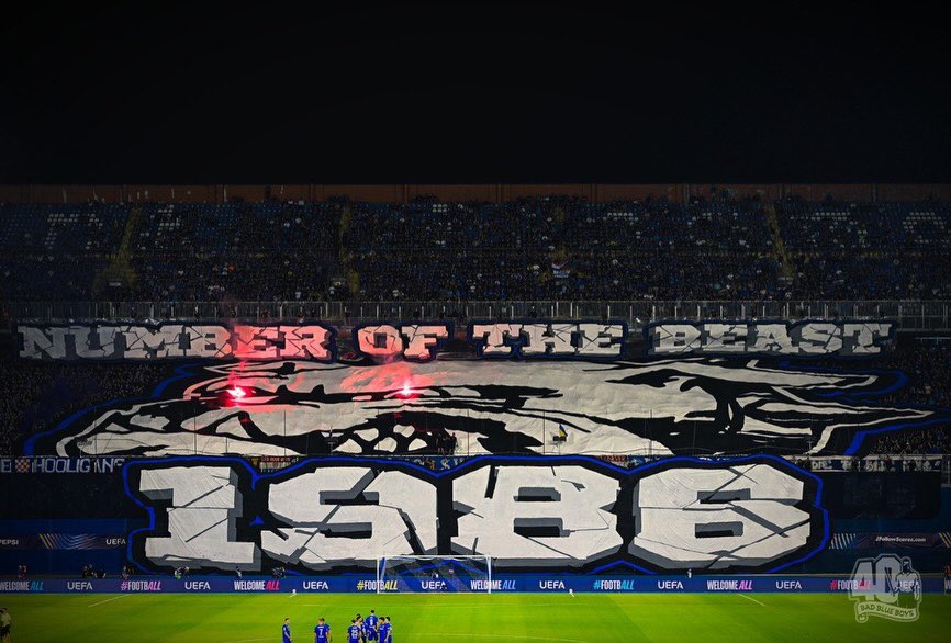UltrasPresent's tweet photo. Tifo de BAD BLUE BOYS 🔵🇭🇷 en homenaje a sus 40 años de historia.

(Sacaron el logo del grupo con los 2 ojos con bengalas y la frase: 

“EL NÚMERO DE LA BESTIA 
1986”

(Despues de eso se llenó el fondo de bengalas)

Dinamo de Zagreb - Viking 🇳🇴
#ChampionsLeague https://t.co/w3QWZegUBw