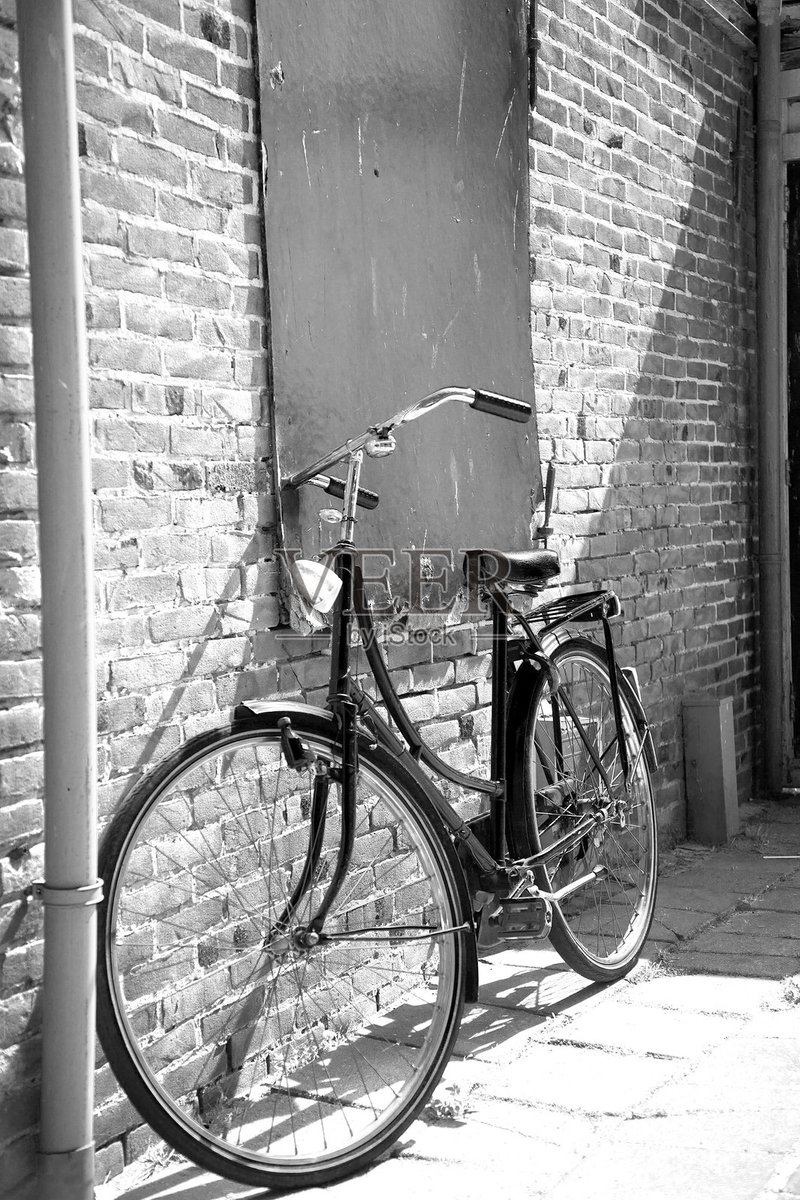 Eslamgo490's tweet photo. Random street snap: the morning sun gilds a vintage bike leaning against a weathered brick wall, with passersby hurrying by in the background. https://t.co/XxZKZsvlwX