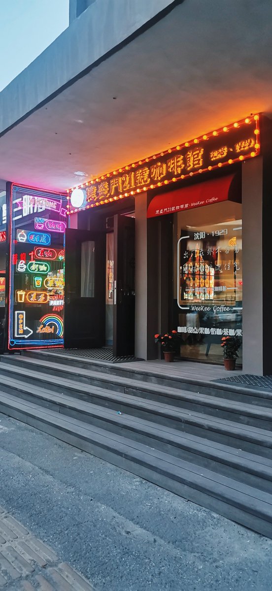 AleMmdoh's tweet photo. Quick street snap: the warm glow of a vintage coffee shop sign against the dusk, passersby hurrying home with their steps.， https://t.co/ycOwvgJx9r