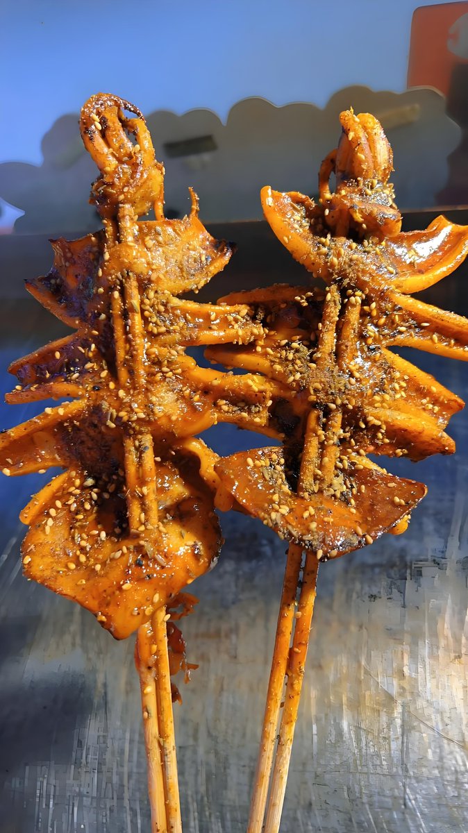 AdiMjcrew's tweet photo. Crunchy fried squid skewers sizzling on the street stall—best late-night snack in the city! ， https://t.co/qdZ6nWu4Zn